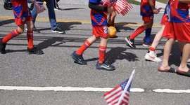 4k footage of Little League team (only legs visible) marching in small town Memorial Day Parade