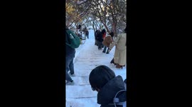 Park visitor slides down on snow-covered steps in China