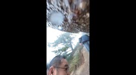 Hiker slips on wet mountain trail as he scales steep slope in China