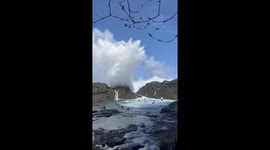 Tourists play in 60ft high white water as waves crash onto rocks