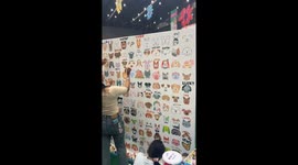 Animal lovers paint dog and cat faces on wall at pet event