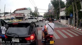 Motorcycle rider and passenger lean sidewards to avoid oncoming bus