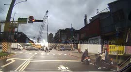 Bungling crane operator drops pole into path of oncoming car