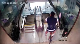 Foolhardy cyclist tumbles down escalator after attempting to ride bike down