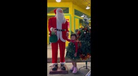 Toddler poses with singing Santa statue in Thailand