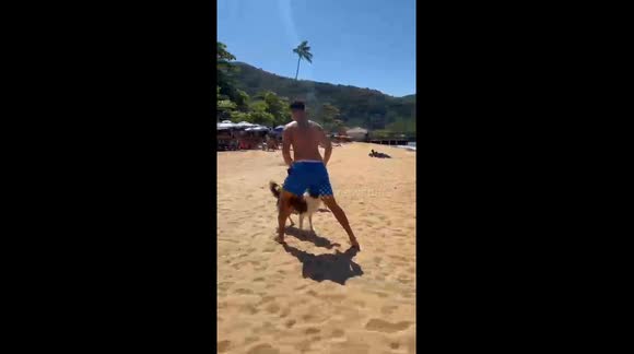Man playing ball with dogs on the beach. Rio de Janeiro, Brazil, 12 November 2025