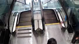 Bungling cyclist rides bike down escalator in China