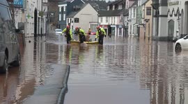 Woman and dog transported through submerged street by rescue team as Welsh town floods