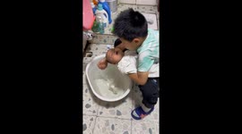 Older brother gently washes baby sibling in Jiangxi, China