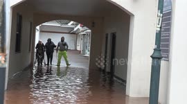 STORM CLAUDIA- ELDERLY WOMAN AT MONMOUTH WADES THROUGH WATER TO SAFETY
