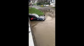 Heavy Flooding Submerges Vehicle on Green Road Ford