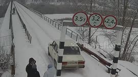 Car slams into height restriction pillar after zigzagging across snow-covered bridge