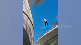 Cleaner appears to float as she wipes transparent roof at plaza
