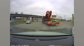 Lorry carrying excavator gets wedged under bridge after driver misjudges height
