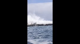 Terrifying moment huge wave sweeps tourists off promenade and into sea