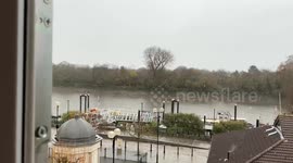 Snowfall sweeps across the Thames River in Chiswick, London