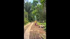 Local balances herself on homemade bamboo cart while riding track with friend