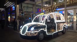 Christmas taxi lighting installation sparkles outside Fulham Broadway shopping centre in London