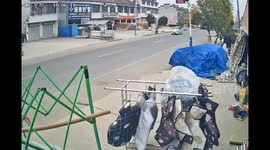 Clothes rack blown into the road weaves through oncoming traffic