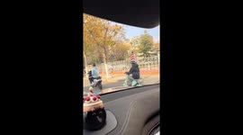 Man rides scooter wearing giant traffic cone as a hat in Shandong, China