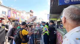 Police speak to a man filming the Trans Day of Resistance Rally 2025