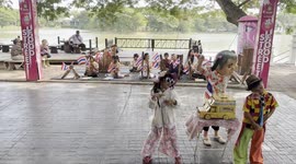 A group of Thai students perform before tourists by dancing to raise money for their school.