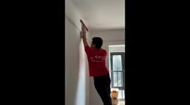 Cat secretly watches a repairman from behind a curtain in Fujian, China