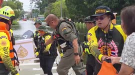 Rescue teams wade through deep flood to carry body of elderly resident to temple