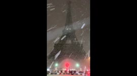 Snow flurries blanket the Eiffel Tower in Paris, France