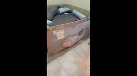 Baby calmly wedged against bedrail in Depok, Indonesia