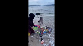 Friends having a picnic by the sea struck by a wave
