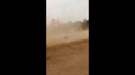 Raging dust devil tornado whips across dry farm field