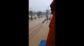 Locals clamber across power lines to escape 8ft deep flood in Thailand