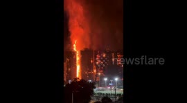 Flames from engulfed tower blocks illuminate night sky in Hong Kong