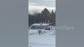 Deer jumps onto snowy roof after escaping enclosure
