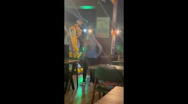 Transformer Dances While Batman Drives a Moped Inside a Bar