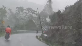 A motorcyclist rides through the heavy rain.