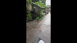 People sliding down slippery street in the rain in Laguna, Philippines
