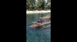Locals use bamboo raft to carry tourist's scooter across sea