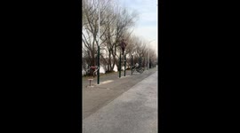 Retired lady balances on workout bar during morning routine in Jilin, China