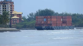 A container barge is stranded in Port Dickson waters near a resort hotel area after being swept away by sea waves following tropical storm Senyar
