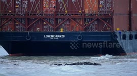 Malaysia: A container barge is stranded in Port Dickson waters near a resort hotel area after being swept away by sea waves following tropical storm Senyar