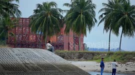 Malaysia: A container barge is stranded in Port Dickson waters near a resort hotel area after being swept away by sea waves following tropical storm Senyar