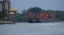 Malaysia: A container barge is stranded in Port Dickson waters near a resort hotel area after being swept away by sea waves following tropical storm Senyar
