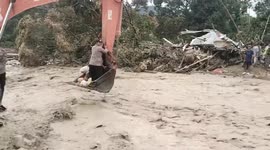 Aid workers use excavator to cross hazardous floodwaters in Sumatra, Indonesia