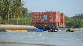 A container barge is stranded in Port Dickson waters near a resort hotel area after being swept away by sea waves following tropical storm Senyar
