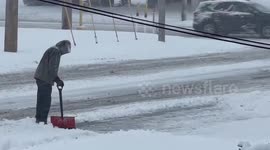 Man clears pathway through heavy snowfall in Highland, Indiana, USA