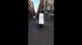 2 men transport a fridge on a motorbike 