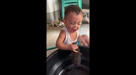 Toddler playfully interacts with duck in Kawit, Cavite, Philippines