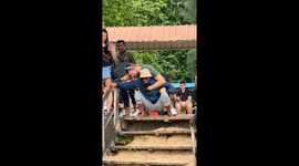 Kind tour guide piggybacks disabled holidaymaker across sand to reach boat